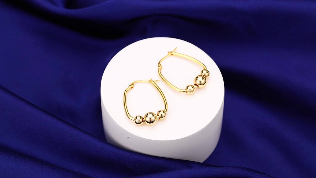 Un set de aretes de aro hechos de plata de ley 925, presentados como un regalo para ella, incluye una caja de regalo